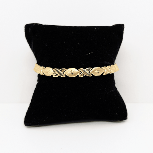 A 10k yellow gold hugs and kisses bracelet with a diamond cut design.
