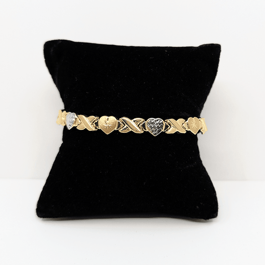 A two-tone (10k yellow and white gold) hugs and kisses with hearts bracelet with a diamond cut design.