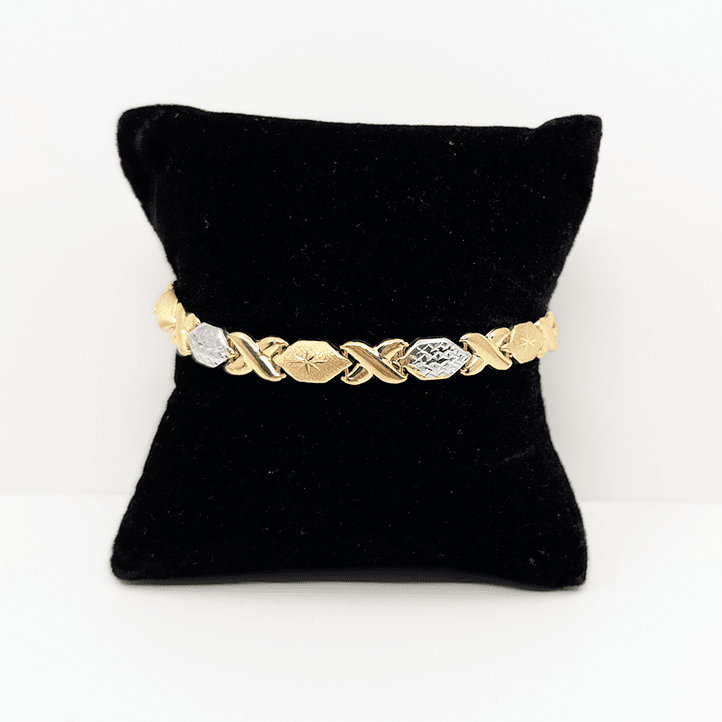 A two-tone (10k yellow and white gold) hugs and kisses bracelet with a diamond cut design.