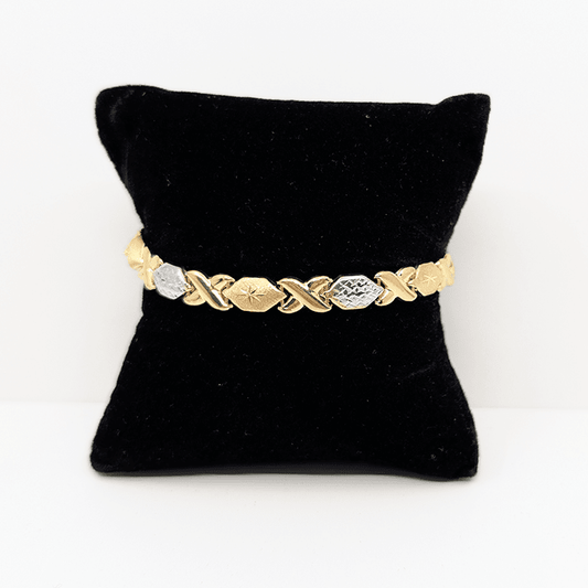 A two-tone (10k yellow and white gold) hugs and kisses bracelet with a diamond cut design.