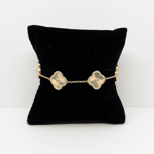 A 14k gold dainty chain bracelet with 14k gold clover charms with a cubic zirconia accent throughout.