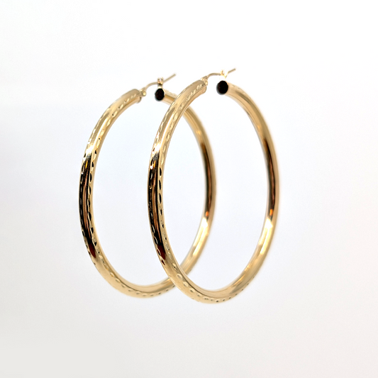 A medium hoop earring with 10k yellow gold and a diamond cut design. 59.2mm Diameter, 4mm Thickness