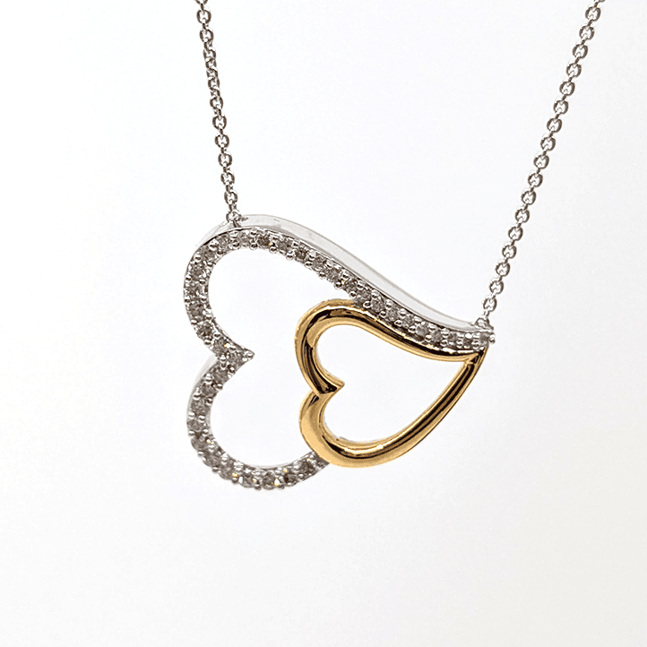 A sterling silver necklace with a dual tone heart pendant, designed with gold plating and .5ctw natural diamond. 