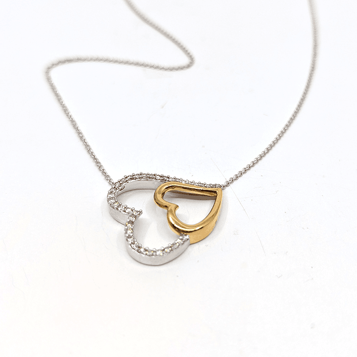 A sterling silver necklace with a dual tone heart pendant, designed with gold plating and .5ctw natural diamond. 